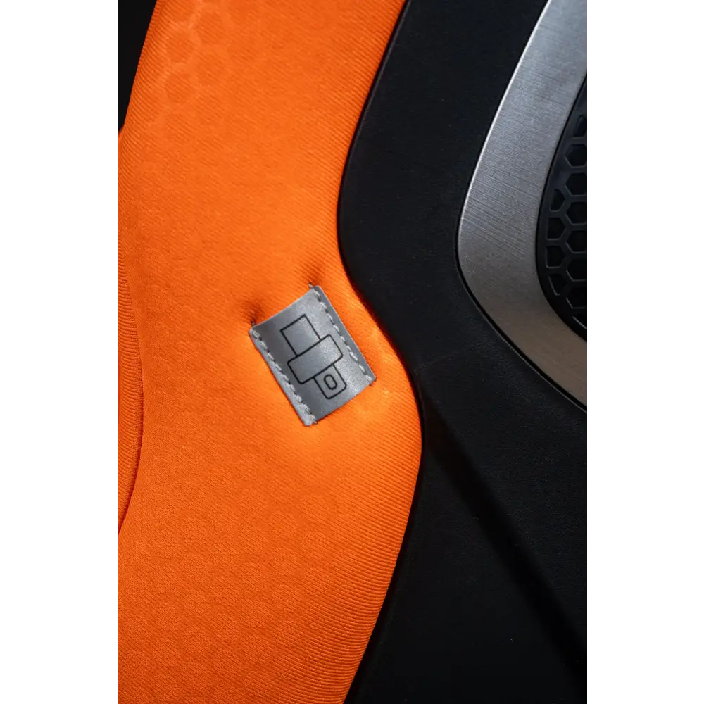 Close-up of orange XENON 1 upholstery with a grey stitched label showing a seat belt symbol.