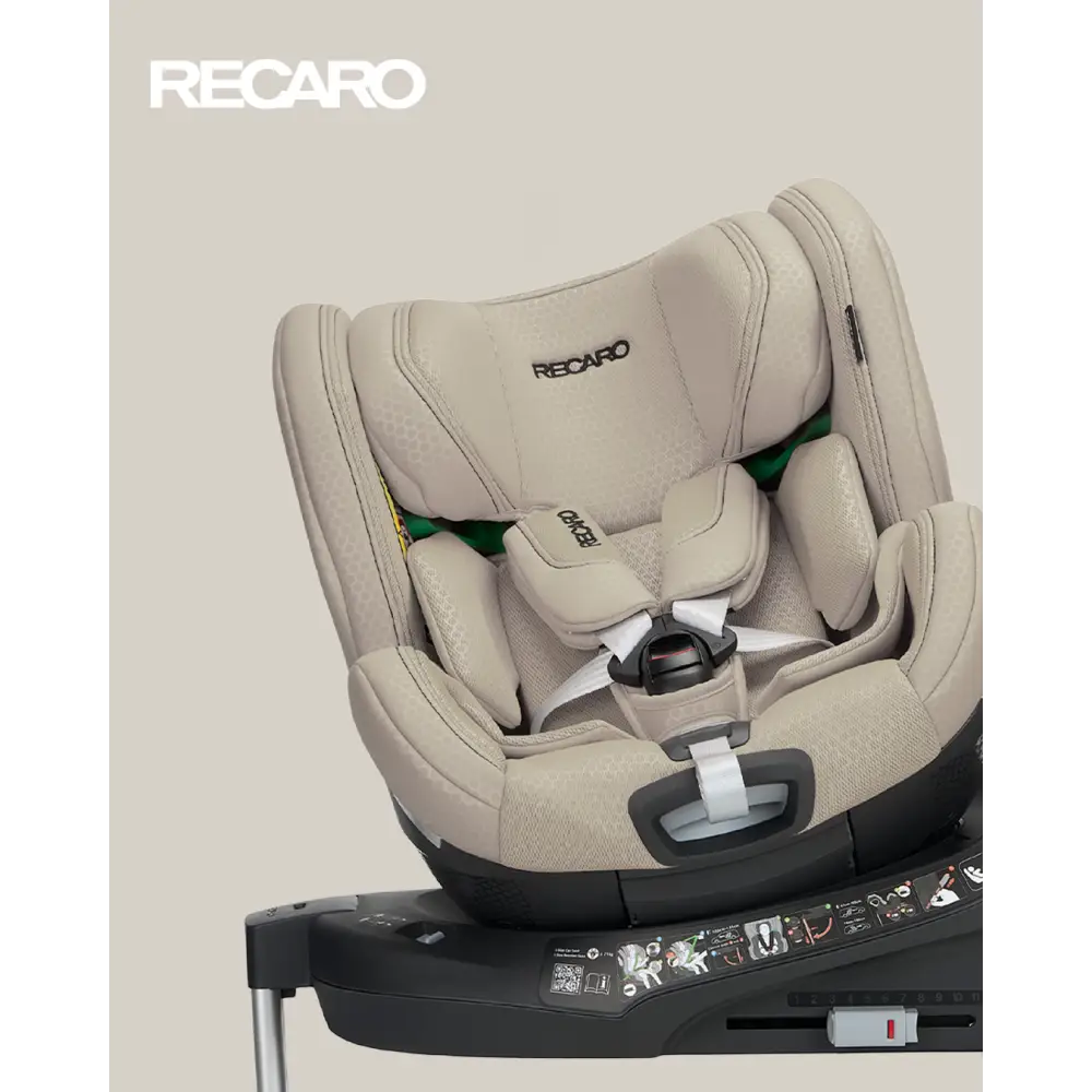Elegant Beige XENON 1 KID, rotated on its base with padded harness beneath a white Recaro logo.