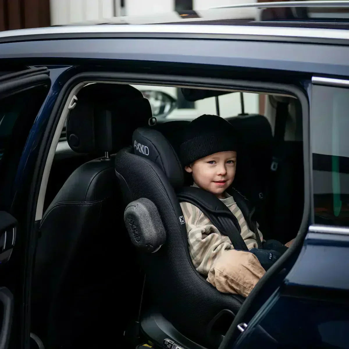 Black ax-kid child safety seat with textured fabric and padded headrest in rear facing position for uk use