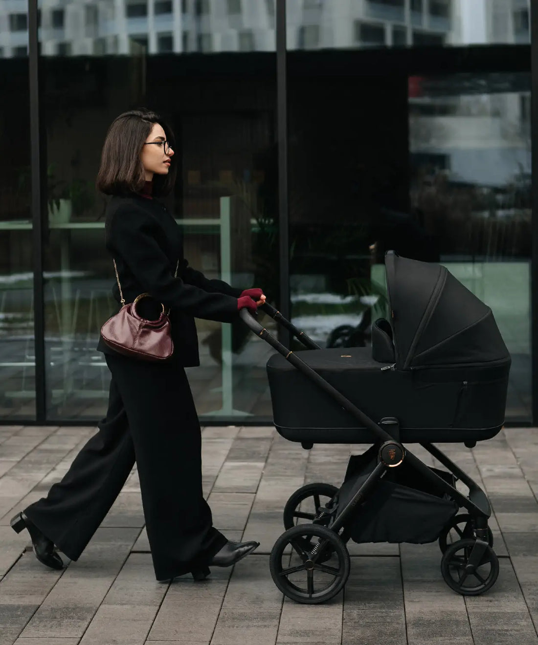 Black stroller with sleek modern design and four wheels shown from the back in best travel systems uk 2026 guide