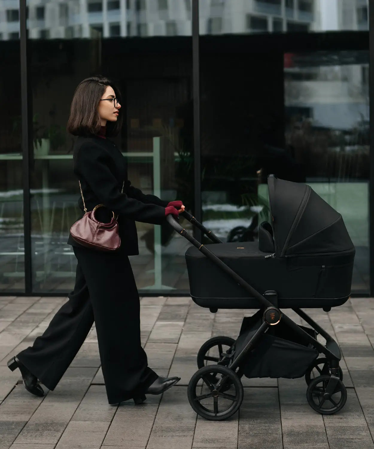 Black stroller with sleek modern design and four wheels shown from the back in best travel systems uk 2026 guide