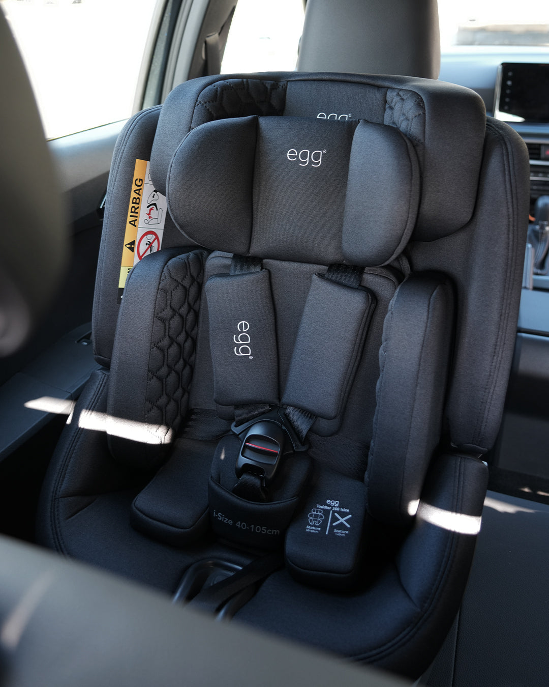 Black egg brand convertible car seat with quilted fabric and padded headrests shown from the back side