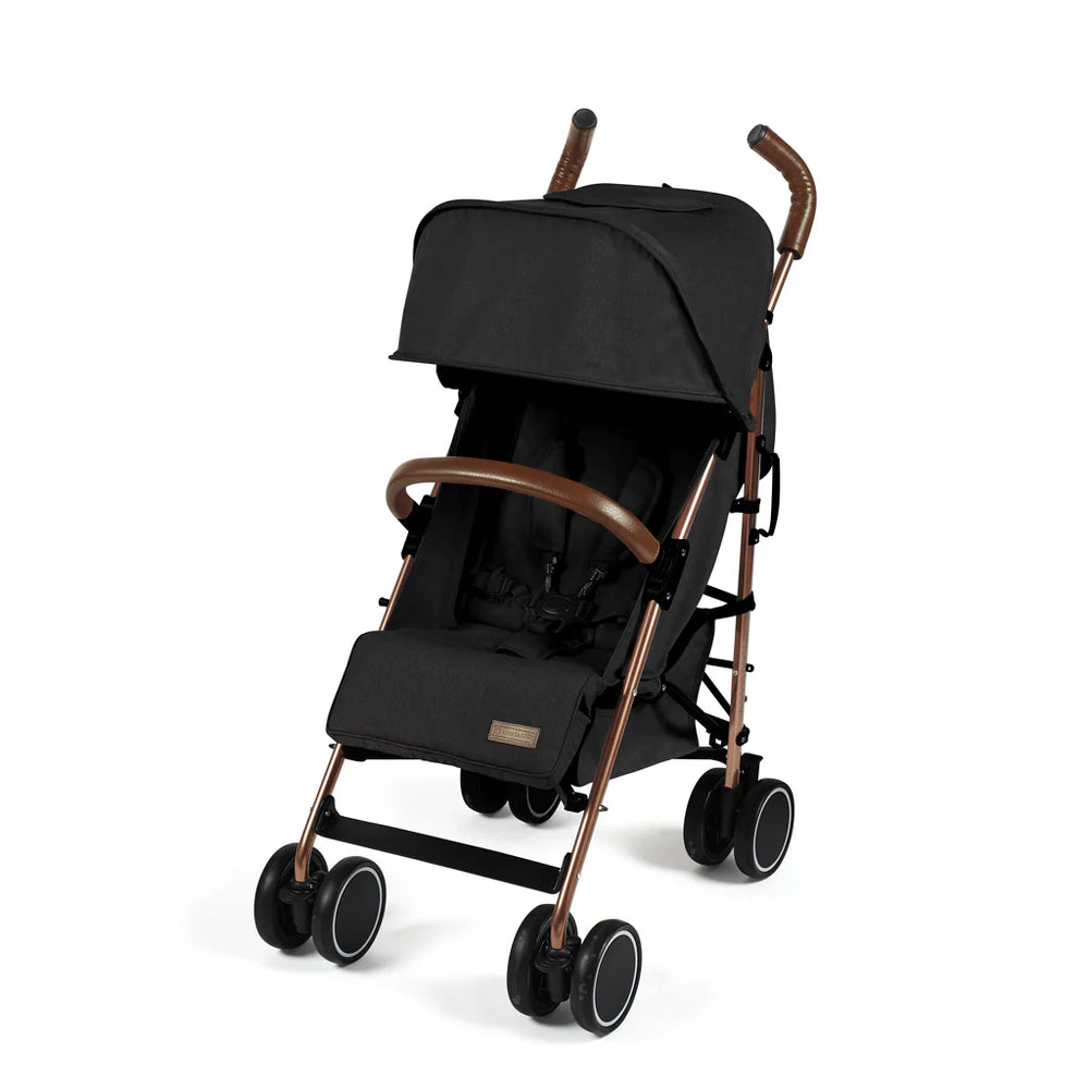 Ickle Bubba Discovery stroller in black with rose gold metallic frame and brown leather-like handles shown from the back side