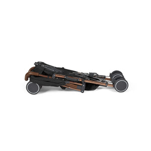 Folded Ickle Bubba Discovery MAX stroller in black with sleek bronze frame and four sturdy wheels