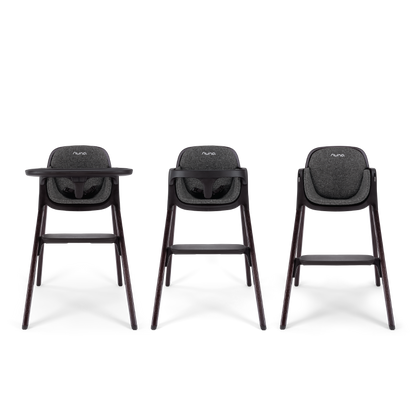 Three nuna bryn highchairs with dark gray fabric seats and sleek wooden legs shown from the front