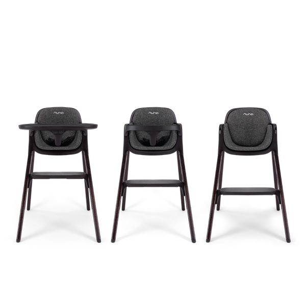 Three nuna bryn highchairs with dark gray fabric seats and sleek wooden legs shown from the front