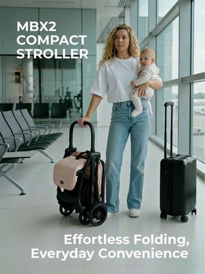 My Babiie MBX2 compact stroller in blush pink features a sleek black frame with soft pink fabric and easy folding
