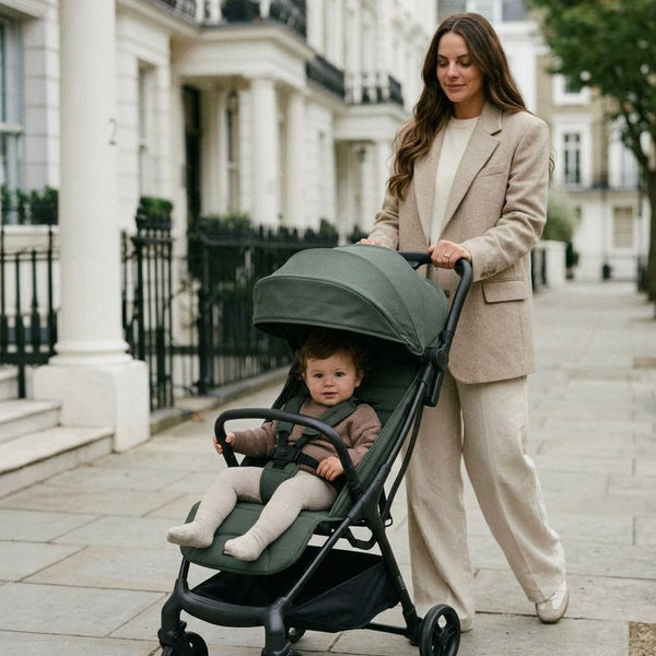 My babiie mbx6 auto-fold compact stroller in olive green with black frame and wheels shown from the back side