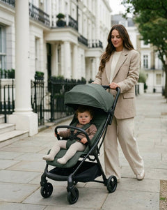 My babiie mbx6 auto-fold compact stroller in olive green with black frame and wheels shown from the back side