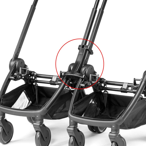 Black plastic stroller handle connector with integrated locking mechanism on the back of peg perego city loop twin 3 in 1 travel system