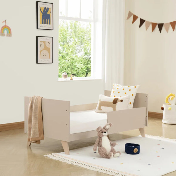 Beige babymore dante toddler bed with minimalist design and angled legs in a cashmere nursery room set