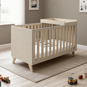 Beige wooden babymore dante cot bed with slatted sides and matching cot top changer in cashmere finish