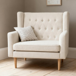 Cream-colored ivory babymore lux snuggle wingback rocking chair with tufted upholstery and light wood legs