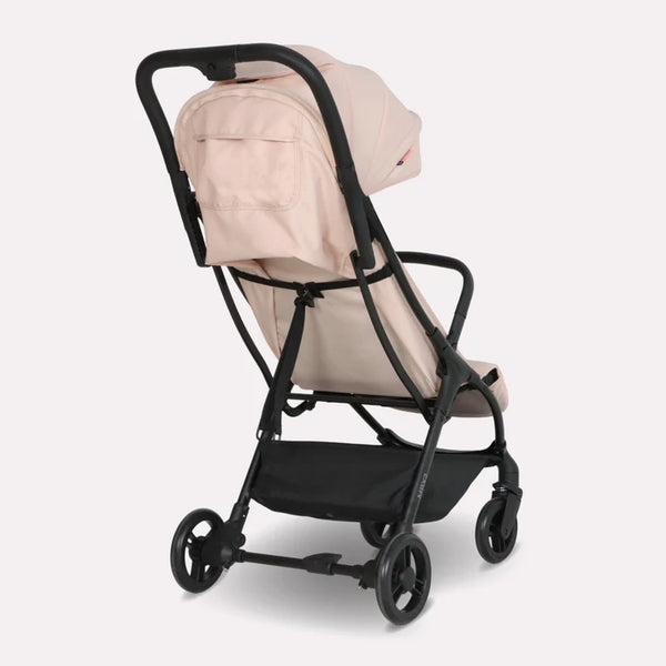 My Babiie MBX2 compact stroller in beige fabric with black metal frame and wheels for easy mobility