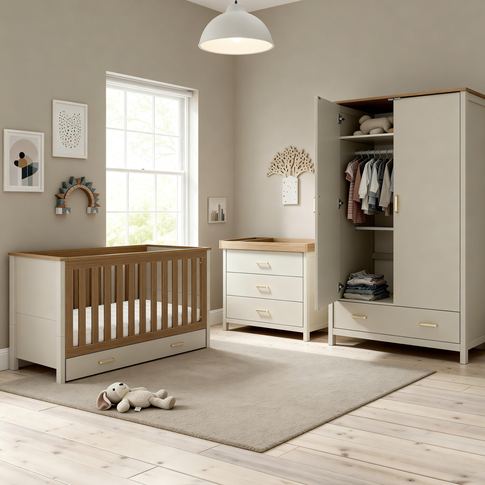 Cream-colored wooden crib with matching changing table and wardrobe featuring light wood accents in cashmere warm oak