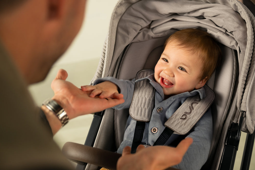 Gray stroller with a soft, padded interior and quilted shoulder straps.
