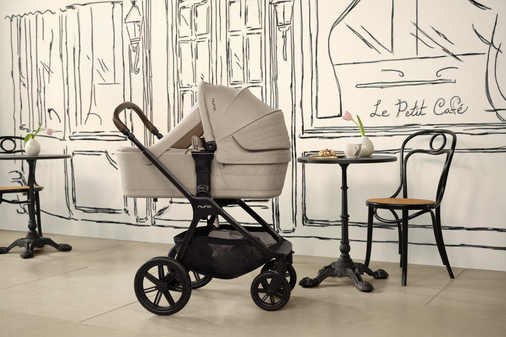 Beige and black baby stroller with a sleek, modern design.