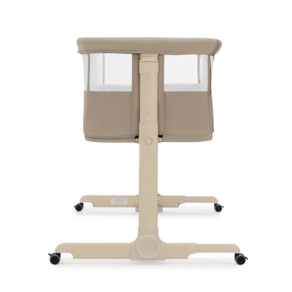 Beige Babymore Neera bedside convertible baby crib with mesh sides and black caster wheels in khaki color