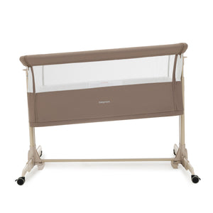 Beige babymore Neera bedside crib with mesh sides and caster wheels for easy mobility in mocha finish