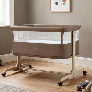 Beige babymore rocking bedside crib with mesh sides and caster wheels in mocha finish for safe infant sleep