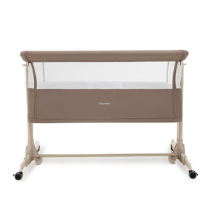 Beige babymore Neera bedside convertible crib with mesh sides and caster wheels for easy mobility in mocha finish