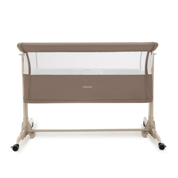 Beige babymore Neera bedside convertible crib with mesh sides and caster wheels for easy mobility in mocha finish