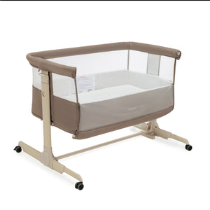 Beige and white babymore neera bedside crib convertible bassinet with mesh sides clear panels and caster wheels