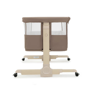 Beige babymore neera bedside crib with mesh sides and wheeled base for easy mobility in mocha finish