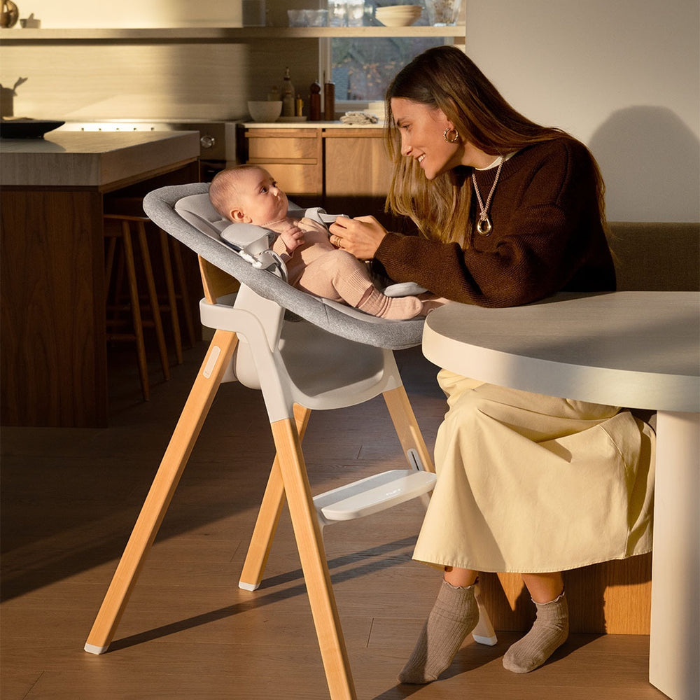 Modern gray and white wooden nuna bryn highchair with adjustable recline for baby feeding and newborn rocking