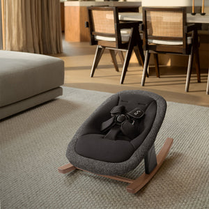 Gray textured fabric baby rocker with black padded seat and wooden base in nuna bryn highchair newborn rocker bundle