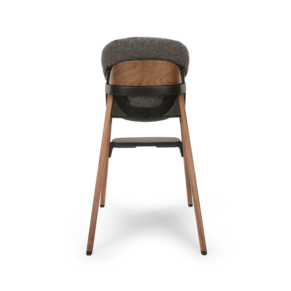 A modern wooden nuna bryn highchair with textured gray fabric seat and backrest black plastic base in sanderson