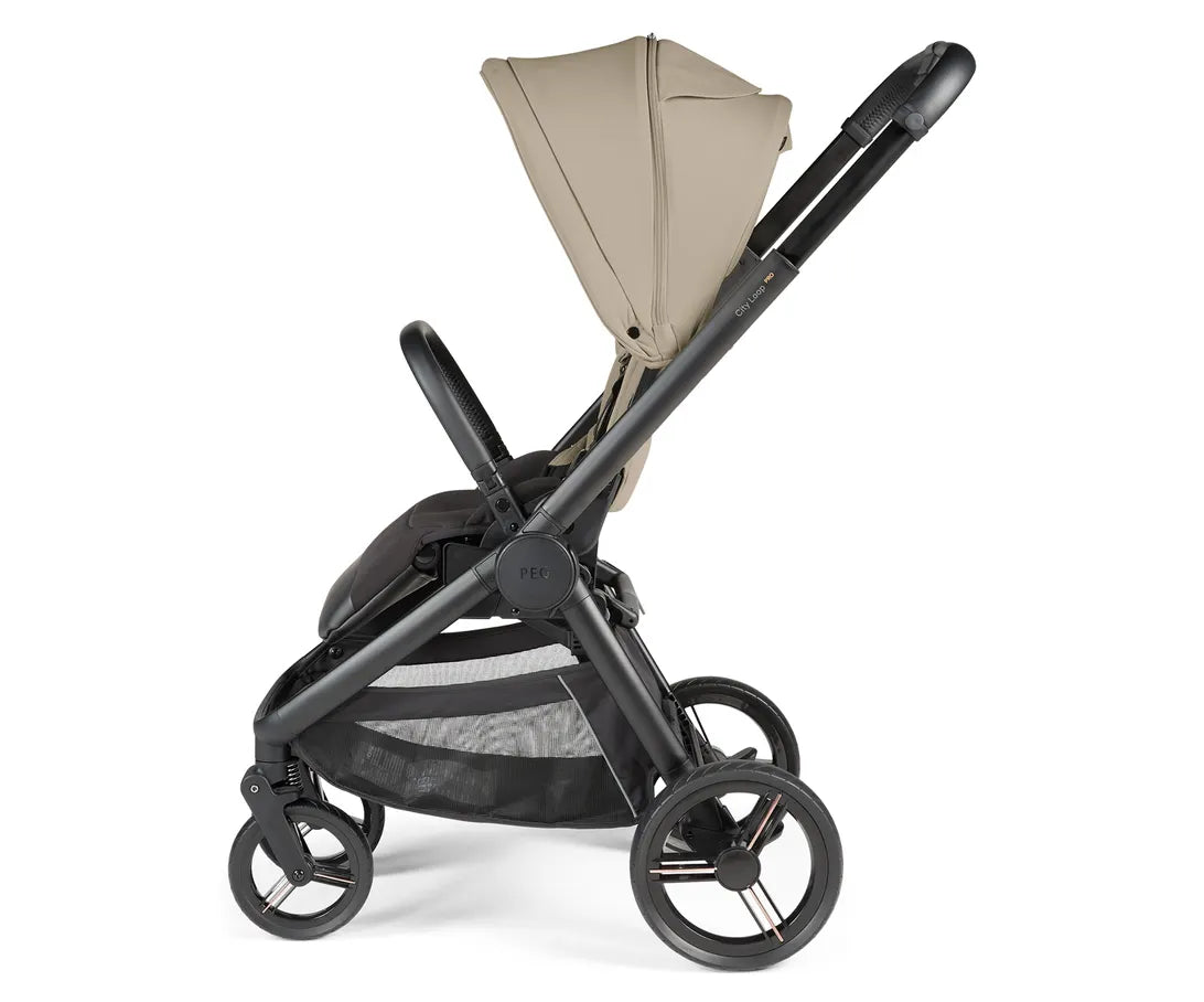 Peg perego city loop pro stroller in black with beige canopy and mesh storage basket shown from the back side