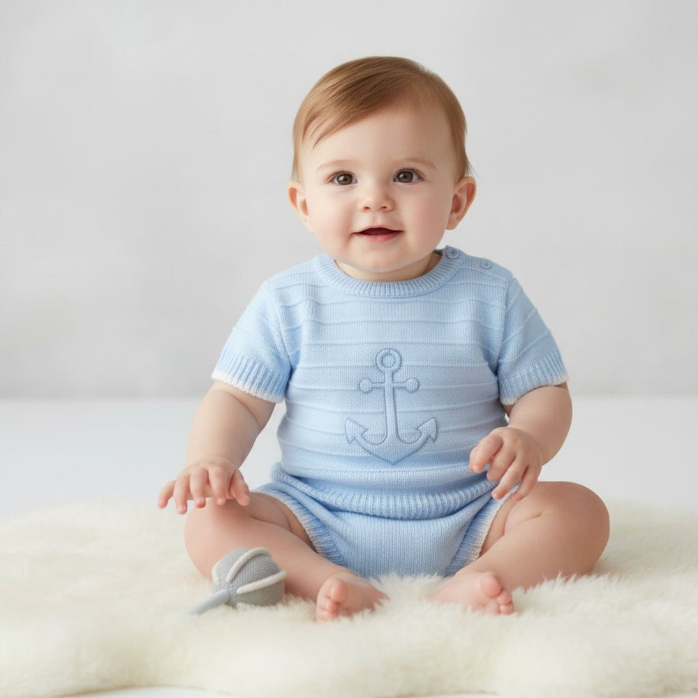 Light blue knitted baby boys onesie with subtle anchor design part of sky blue anchor knit outfit top and jam pant shorts