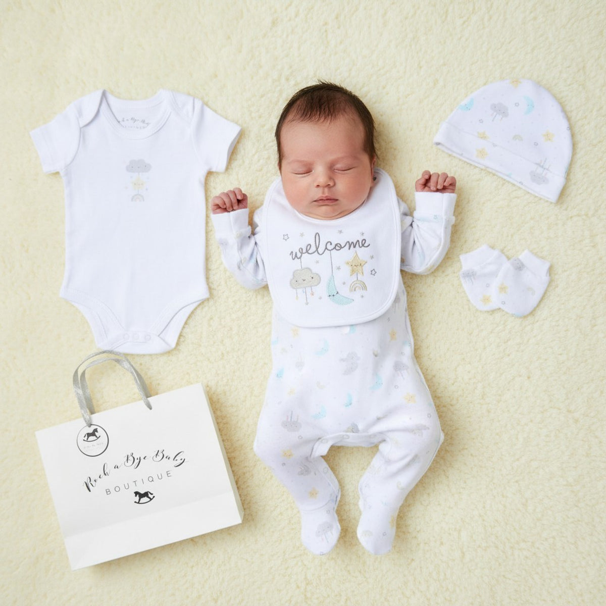 White baby onesie with subtle pastel cloud and star print from unisex welcome 5 piece layette set