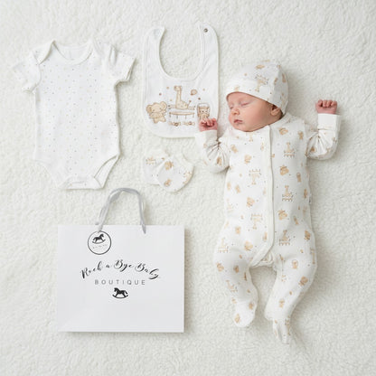 A sleeping baby wearing a white cotton unisex play time 5 piece layette set with beige animal prints and matching hat and bib