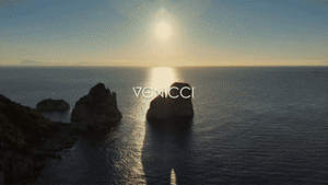 Venicci tila 2 in 1 travel system pram and pushchair with carrycot in noce shown against a venice inspired coastal scene