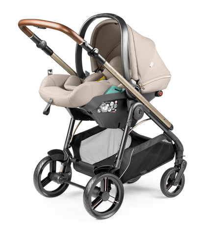 Beige and black peg perego veloce lite travel system stroller with wooden handle metal frame and four wheels
