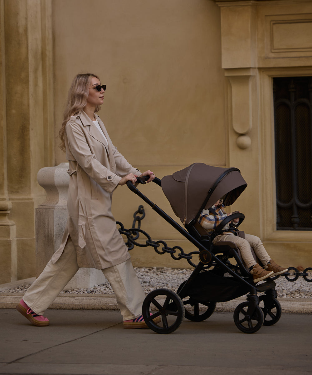 Black stroller with a brown canopy and four wheels