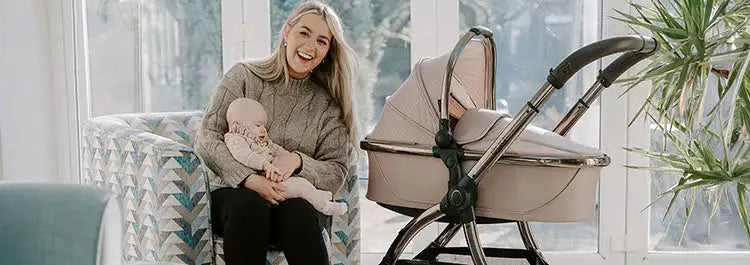 Beige pram with a sleek metallic frame and soft, padded canopy.
