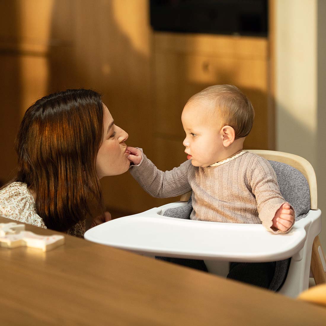 Nuna BRYN highchair white with gray cushioned seat and tray designed for comfortable infant seating and feeding