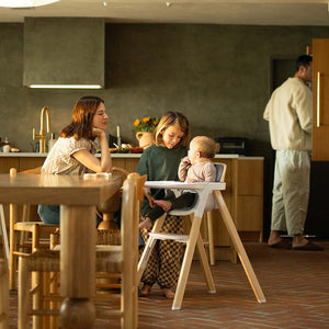 White wooden highchair with modern minimalist design and padded seat nuna bryn highchair heritage model