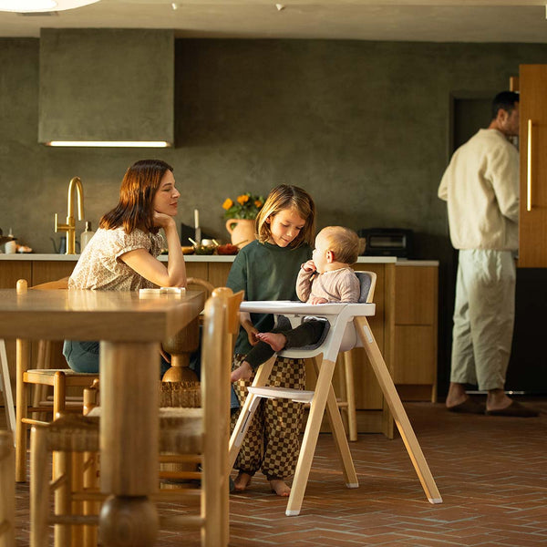 White wooden highchair with modern minimalist design and padded seat nuna bryn highchair heritage model