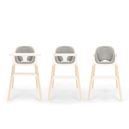 Three modern Nuna BRYN highchairs with light wood legs white plastic frames and gray upholstered seats in heritage style