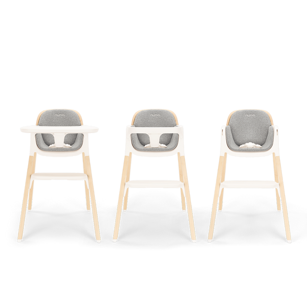 Three modern Nuna BRYN highchairs with light wood legs white plastic frames and gray upholstered seats in heritage style