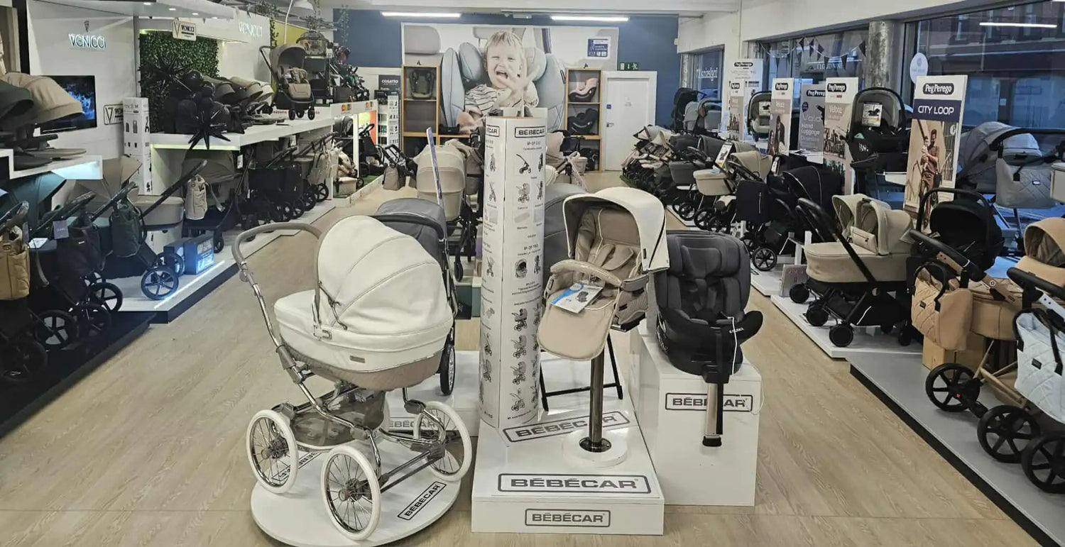 Cream-colored, four-wheeled pram with a rounded canopy and metallic frame.