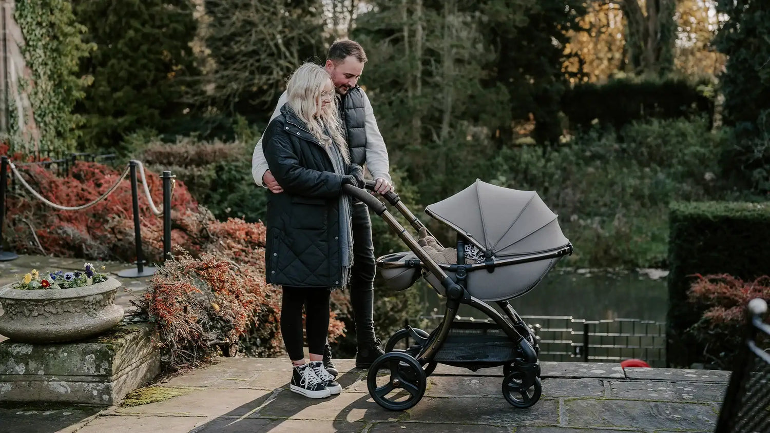 Gray fabric canopy stroller with black metal frame and wheels.