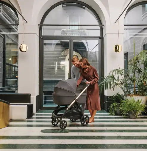  Gray stroller with a sleek, modern design and black wheels.