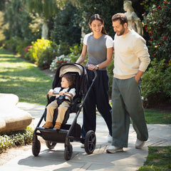 Nuna mixx next stroller in caviar black with beige canopy featuring a child seated inside for comfortable strolling