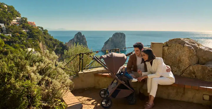 Modern taupe-colored stroller with sleek, minimalist design and black wheels.