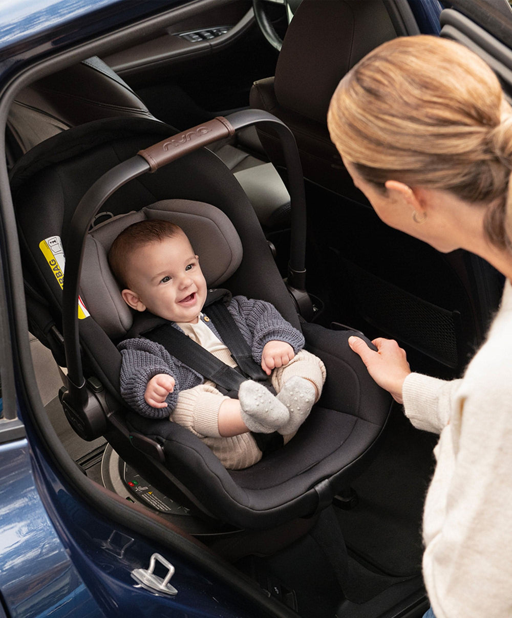 Black and gray nuna baby car seat with brown leather accents